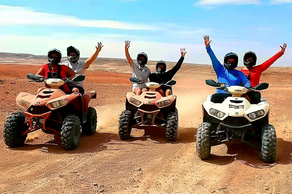 Adventurers on quad bikes zooming through the vast, rugged terrain of the Agafay Desert, kicking up trails of dust against a backdrop of endless dunes and a brilliant blue sky.